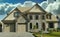 Grand Designer Home House Maison Rock Stucco Front Exterior Cumulus Clouds Sky Background