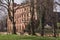 A grand old building in an urban park at the start of spring