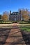 Grand old historic home in a well landscaped yard with shadows creeping across the yard at sunset