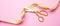 Grand opening. Gold scissors cutting golden ribbon, pink background, banner