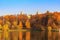 Grand palace on a background of pond and trees with golden leaves on shore in Tsaritsyno park in Moscow at sunny autumn day