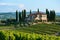 A grand, spacious house stands proudly on a lush green hill, commanding attention with its expansive presence, A Tuscan villa