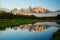 The Grand Tetons reflect at sunrise at Schwabacher`s Landing