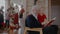 Grandad reading a book with granddaughter, everyone preparing for Christmas Eve