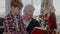 Grandad reading a book with grandson sitting on a chair at Christmas celebration