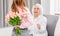 Grandaughter gives flowers to grandmother