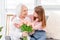 Grandaughter gives flowers to grandmother