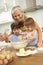 Grandchildren Helping Grandmother To Bake Cakes In Kitchen