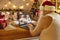 Granddad in undershirt, Santa hat and beard video calling his family on Christmas Eve