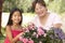 Granddaughter And Grandmother Gardening Together