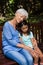 Granddaughter and grandmother sleeping while sitting on wooden bench