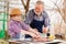 granddaughter helps grandfather cook barbecue and puts the meat on the grill