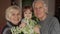 Granddaughter kissing senior smiling grandfather with grandmother at home