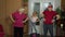 Granddaughter and mature grandparents in sportswear making sports jogging workout exercises at home