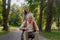 Granddaughter pushing the grandfather in wheelchair in city park.