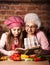 Granddaughter reading recipe book with granny