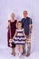 The granddaughter sits on a swing, and grandparents are standing nearby, photo on a gray background