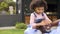 Granddaughter Surprising Grandfather Resting On Seat In Garden At Home