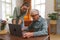 Granddaughter teaching grandfather how to use notebook.