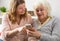 Granddaughter teaching grandma how to use smartphone