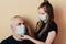 Granddaughter teenager puts a mask on his grandfather face with care to protect him from the virus. Quarantine isolation due to ou