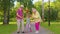 Granddaughter together with senior grandmother grandfather listening to music, dancing crazy in park