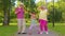 Granddaughter together with senior grandmother grandfather listening to music, dancing crazy in park