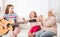 Granddaughters with grandmother listening the guitar