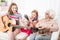 Granddaughters with grandmother listening the guitar