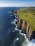 Grandeur of a rugged coastline. From high above, the dramatic cliffs, crashing waves. AI generated