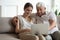 Grandfather and adult granddaughter spend time together use laptop