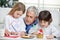 Grandfather Assisting Children In Writing Letters