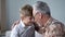 Grandfather and boy leaning foreheads together, visit on weekend, elderly care