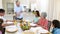 Grandfather carving chicken at dinner table