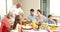 Grandfather carving chicken at dinner table for his family