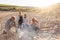 Grandfather Cooking As Multi-Generation Family Having Evening Barbecue Around Fire On Beach Vacation