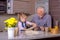 Grandfather cooking something with his adorable granddaughter  in the kitchen