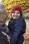 Grandfather Cuddling Granddaughter On Autumn Walk