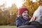 Grandfather Cuddling Granddaughter On Autumn Walk