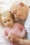 Grandfather Cuddling Granddaughter In Bed