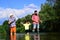 Grandfather, father and son are fly fishing on river. Anglers. Family bonding.