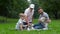 Grandfather, father and son and two dogs Jack russel terrier lying on the green grass in the summer park. Family