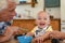 Grandfather feeding happy little boy