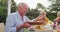 Grandfather feeding his grandson while having lunch outdoors