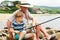 Grandfather fisher in straw hat and little male grandkid enjoying leisure activity use fishing rod