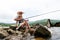 Grandfather fisher in straw hat and little male grandkid enjoying leisure activity use fishing rod