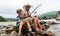 Grandfather fisher in straw hat and little male grandkid enjoying leisure activity use fishing rod