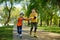 Grandfather giving roller skating class for little boy in park