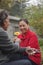 Grandfather giving smiling grandmother a flower in the garden