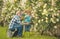 Grandfather and grandchild enjoying in the garden with roses flowers. Cute little boy watering flowers in the summer